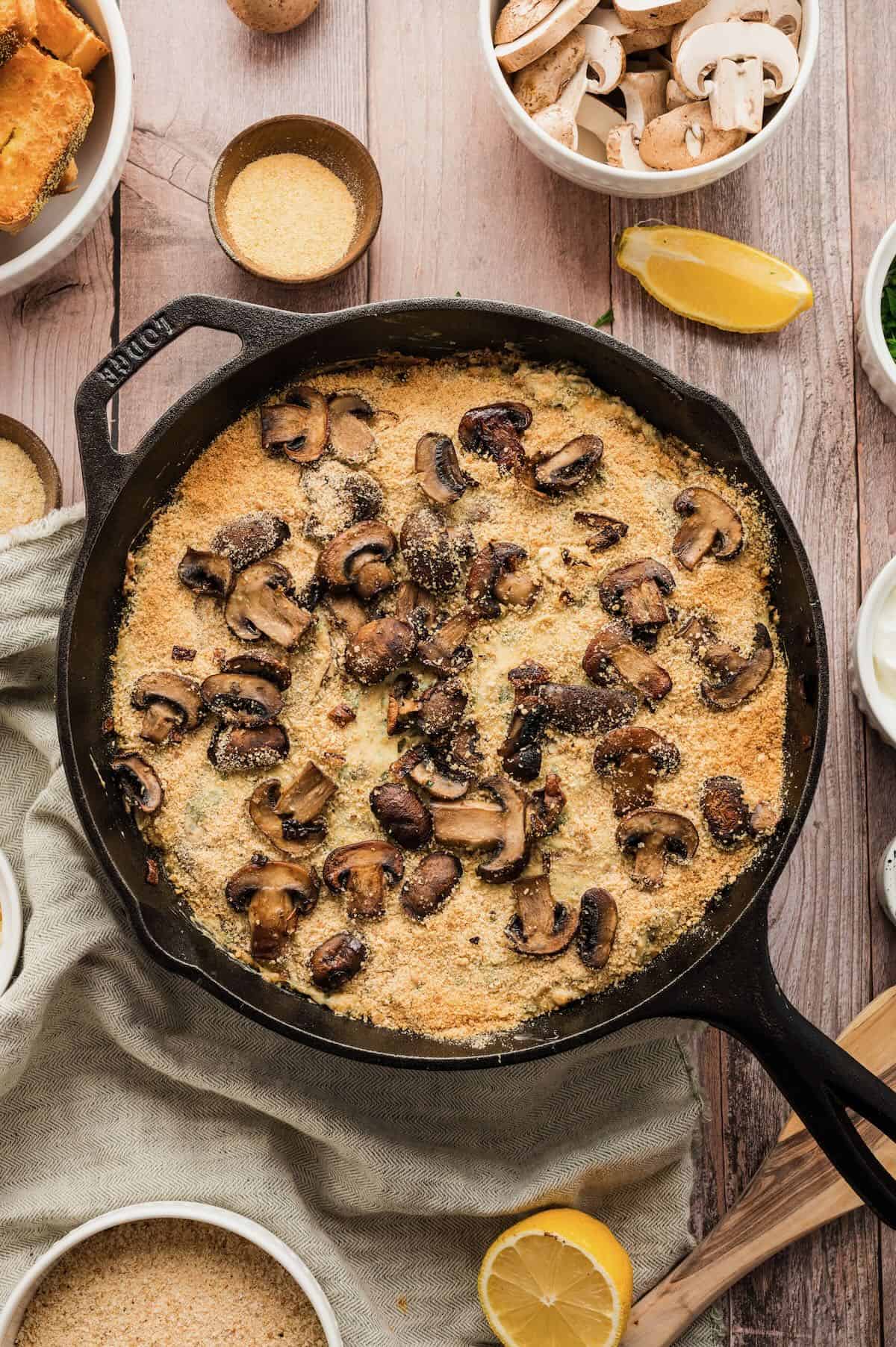 Baked mushroom dip in a cast iron skillet topped with toasted bread crumbs. 