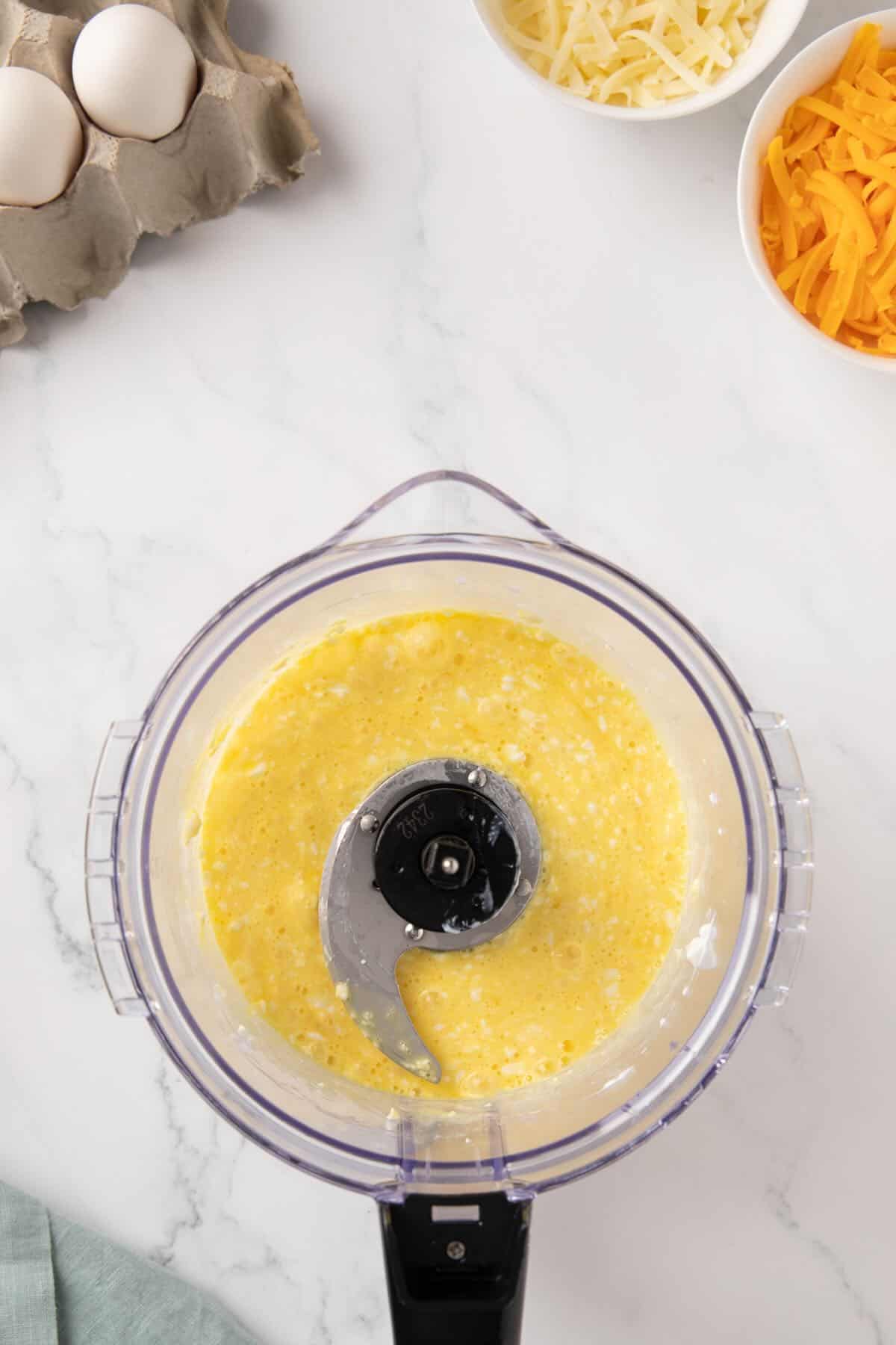Eggs, and cottage cheese being processed together in a good processor. 
