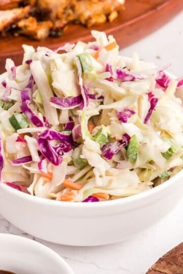 A bowl of spicy coleslaw with red and green cabbage.