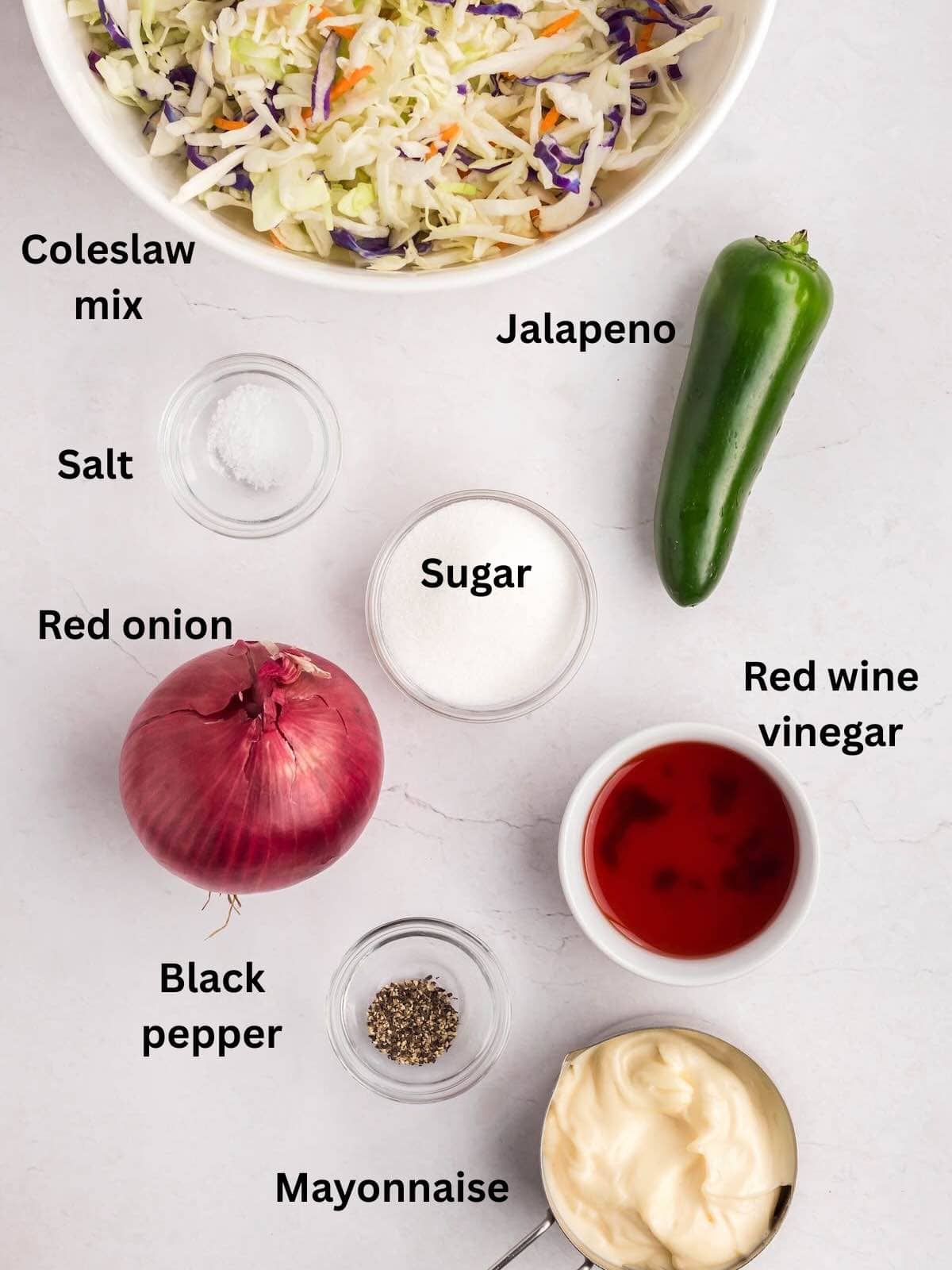 Spicy coleslaw ingredients include mayonnaise, red wine vinegar, jalapeno, onion, and a bag of coleslaw mix.  