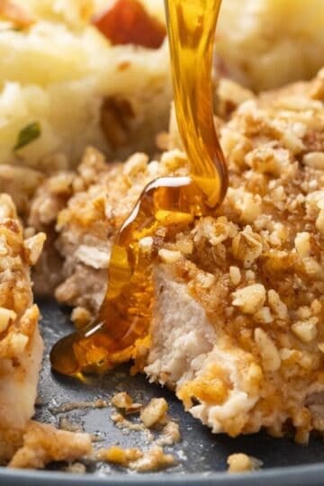 Sliced pecan-crusted chicken breast topped with a drizzle of hot honey.