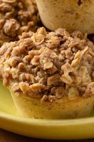 Cinnamon Oatmeal Muffins with a brown sugar and pecan streusel stacked on a platter.
