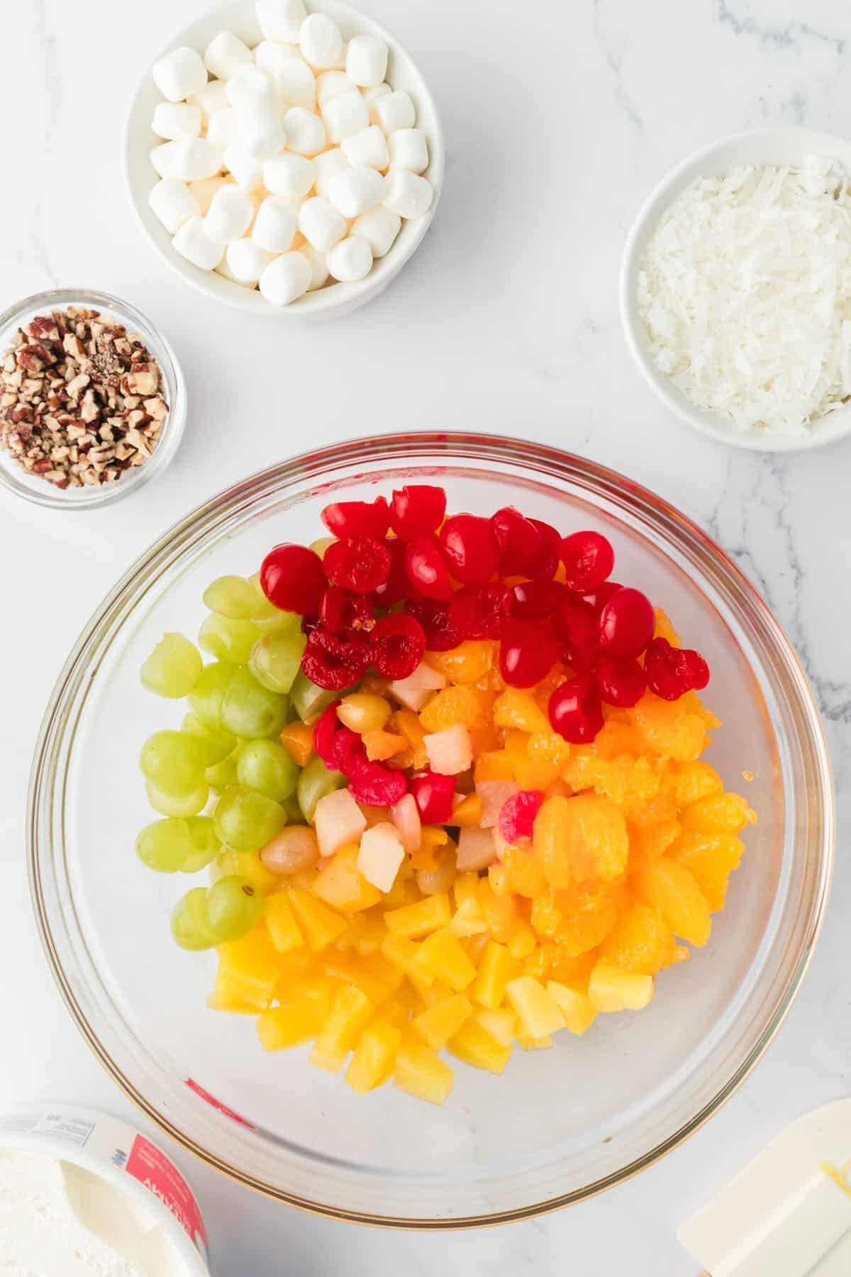 Canned and drained fruit cocktail, mandarin oranges, grapes, and cherries in a bowl.  