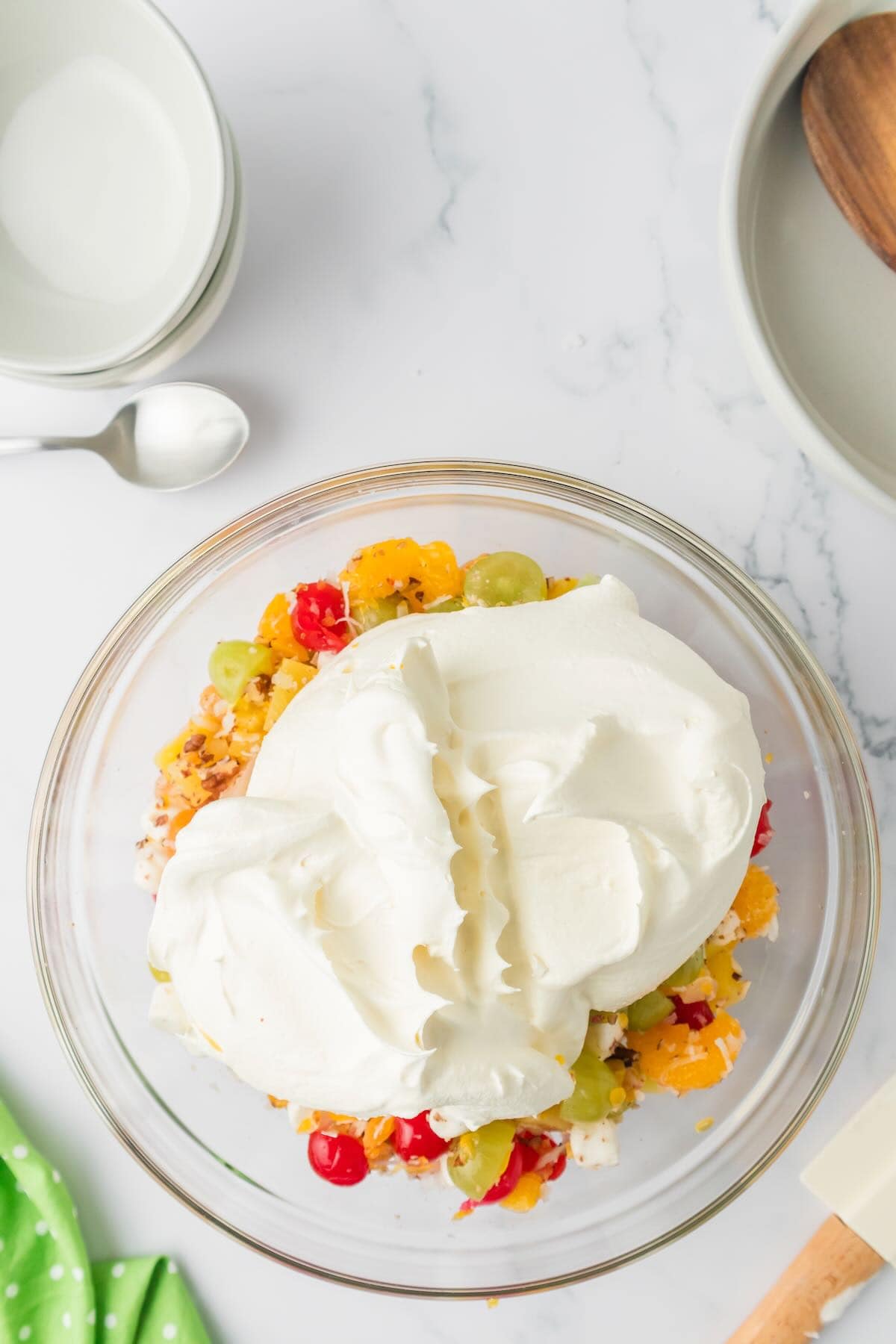 Cool Whip is added to the fruit mixture, coconut, nuts, and marshmallows. 