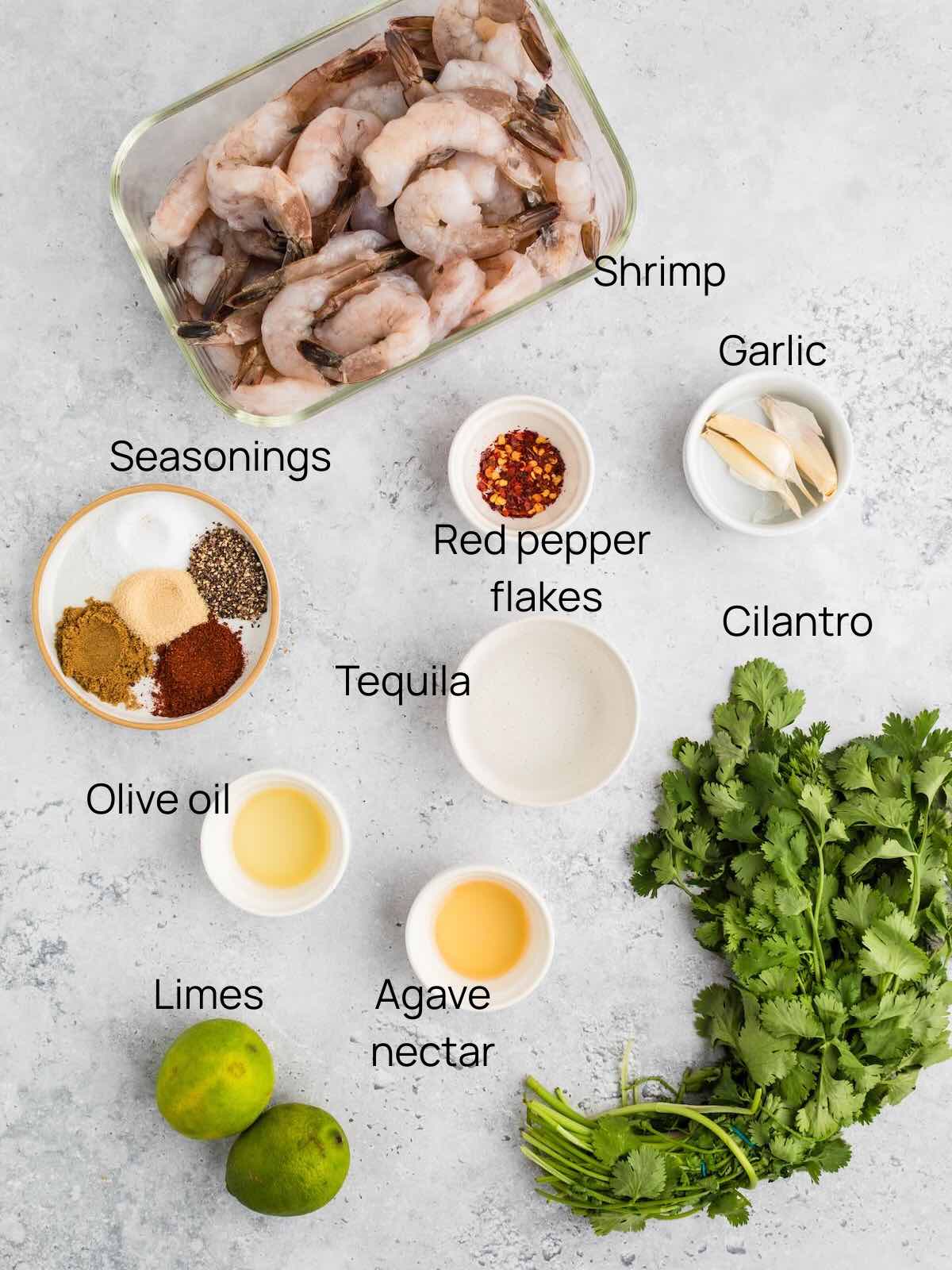 Ingredients for tequila lime shrimp include cilantro, raw shrimp, seasonings, garlic, tequila, and agave nectar. 