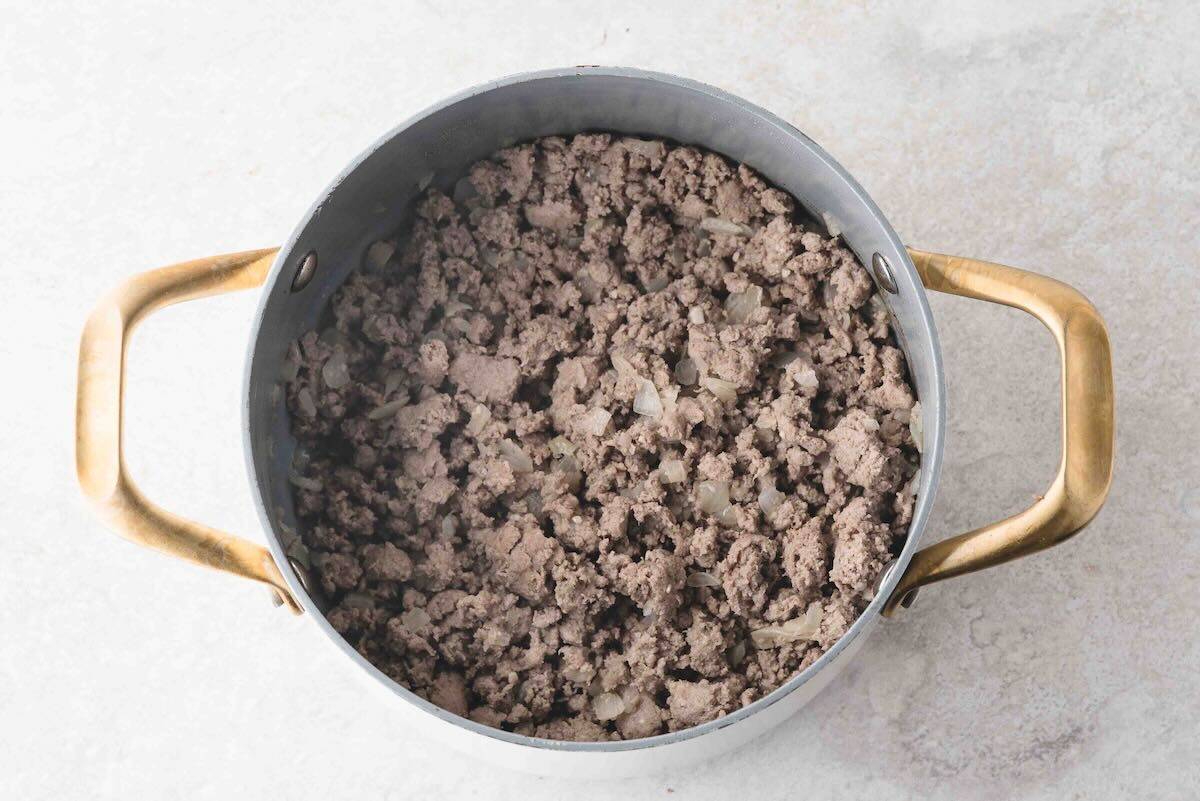 Ground beef is browning in a Dutch oven.