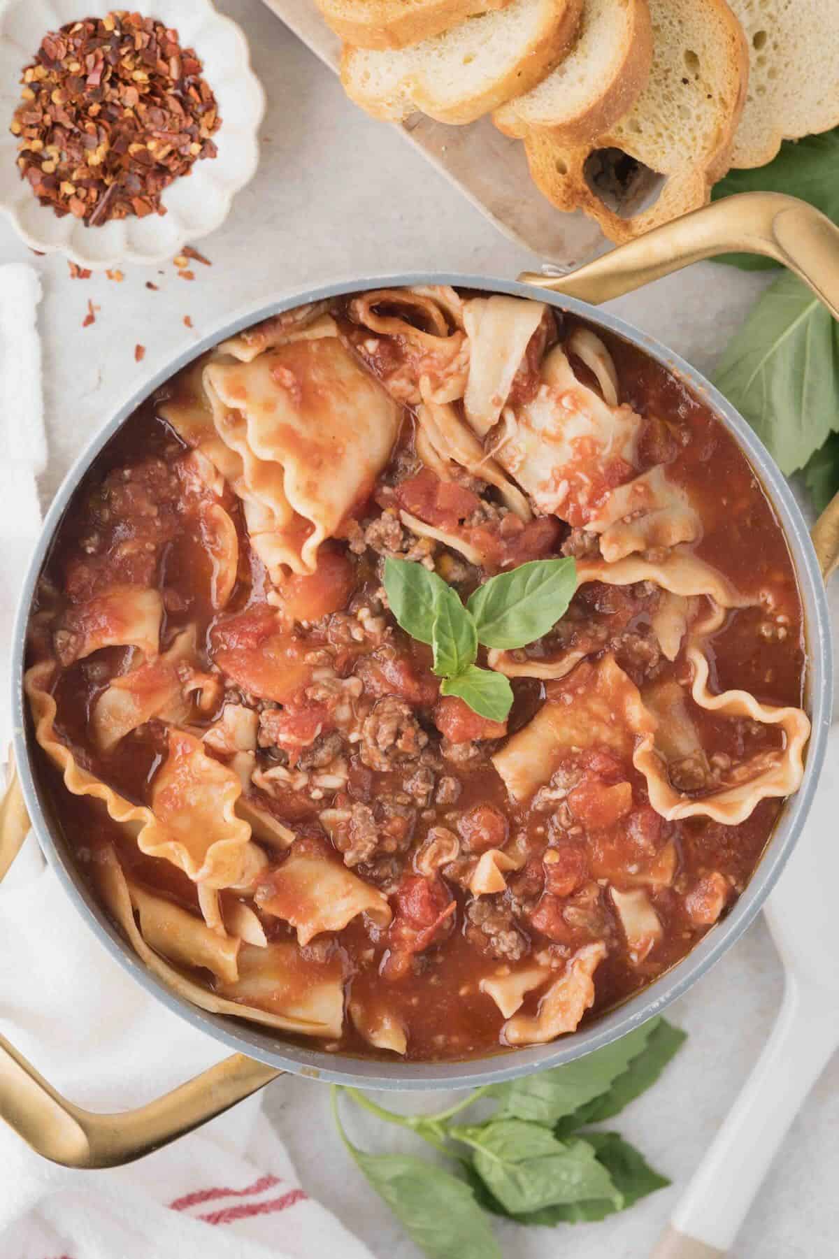 Cooked lasagna soup in a pot with ground beef and lasagna noodles in a tomato sauce.