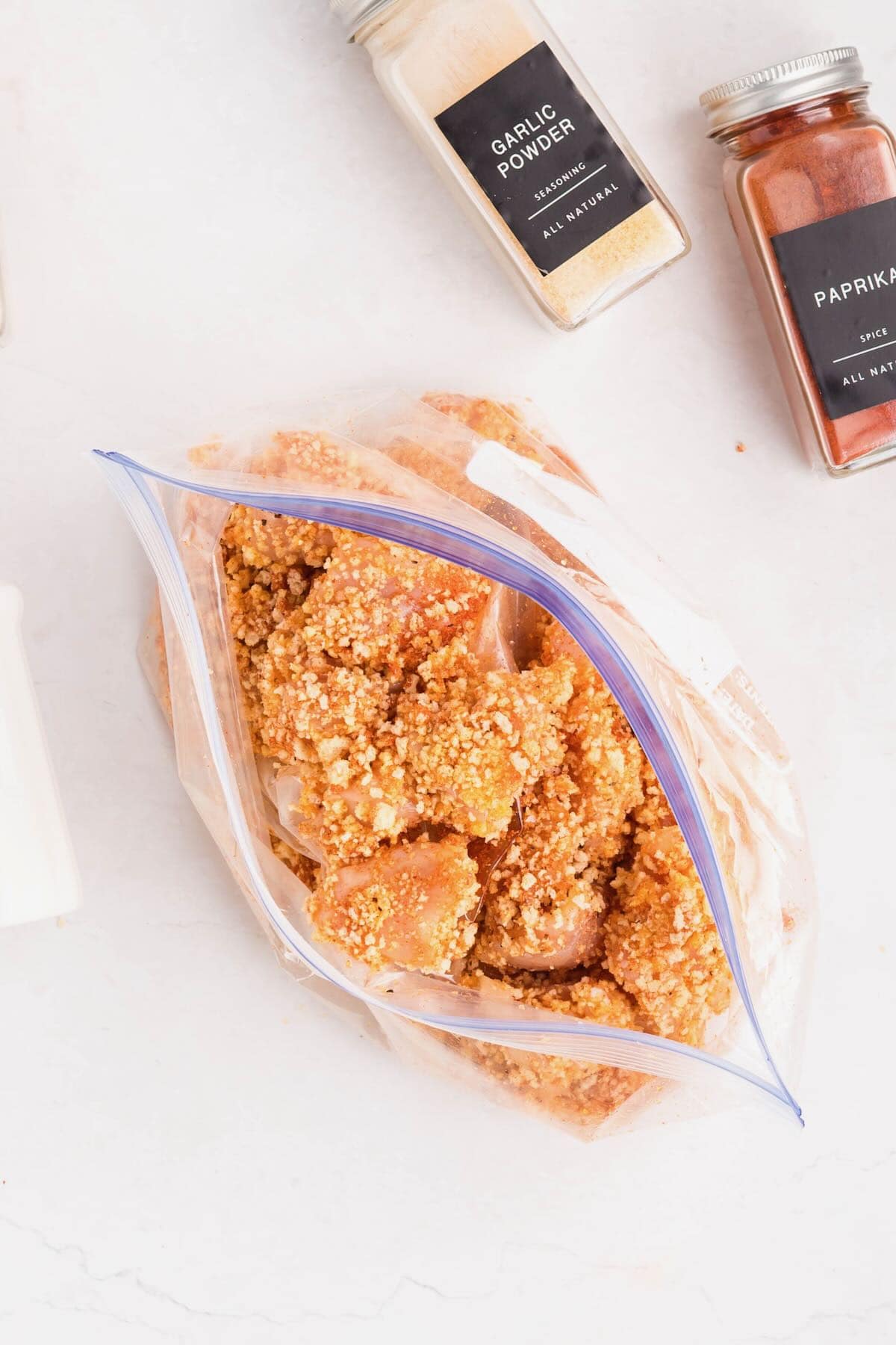 The coated chicken is added to the bag with panko and other seasonings.