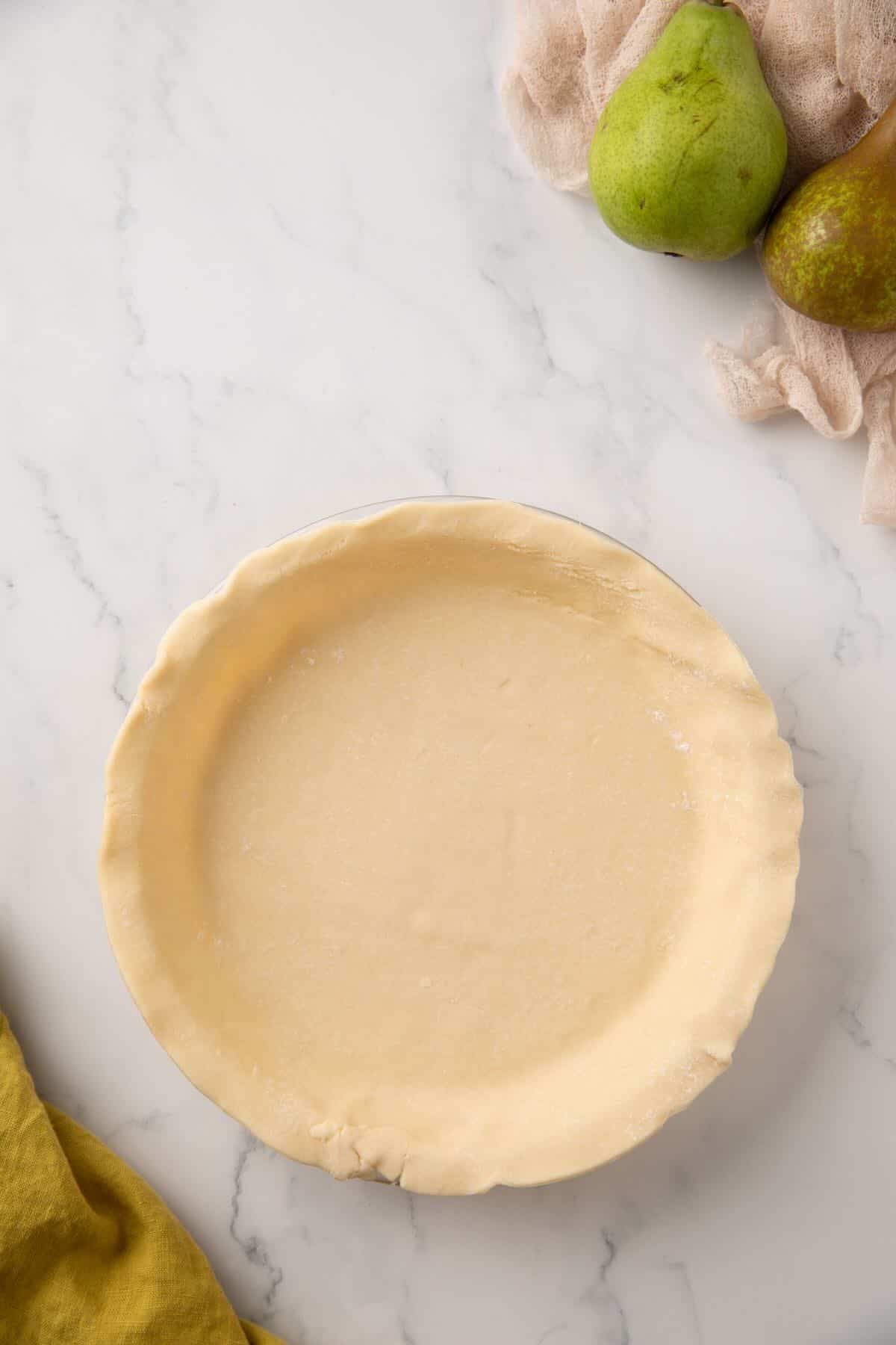 Adding a pie crust to a pie plate. 