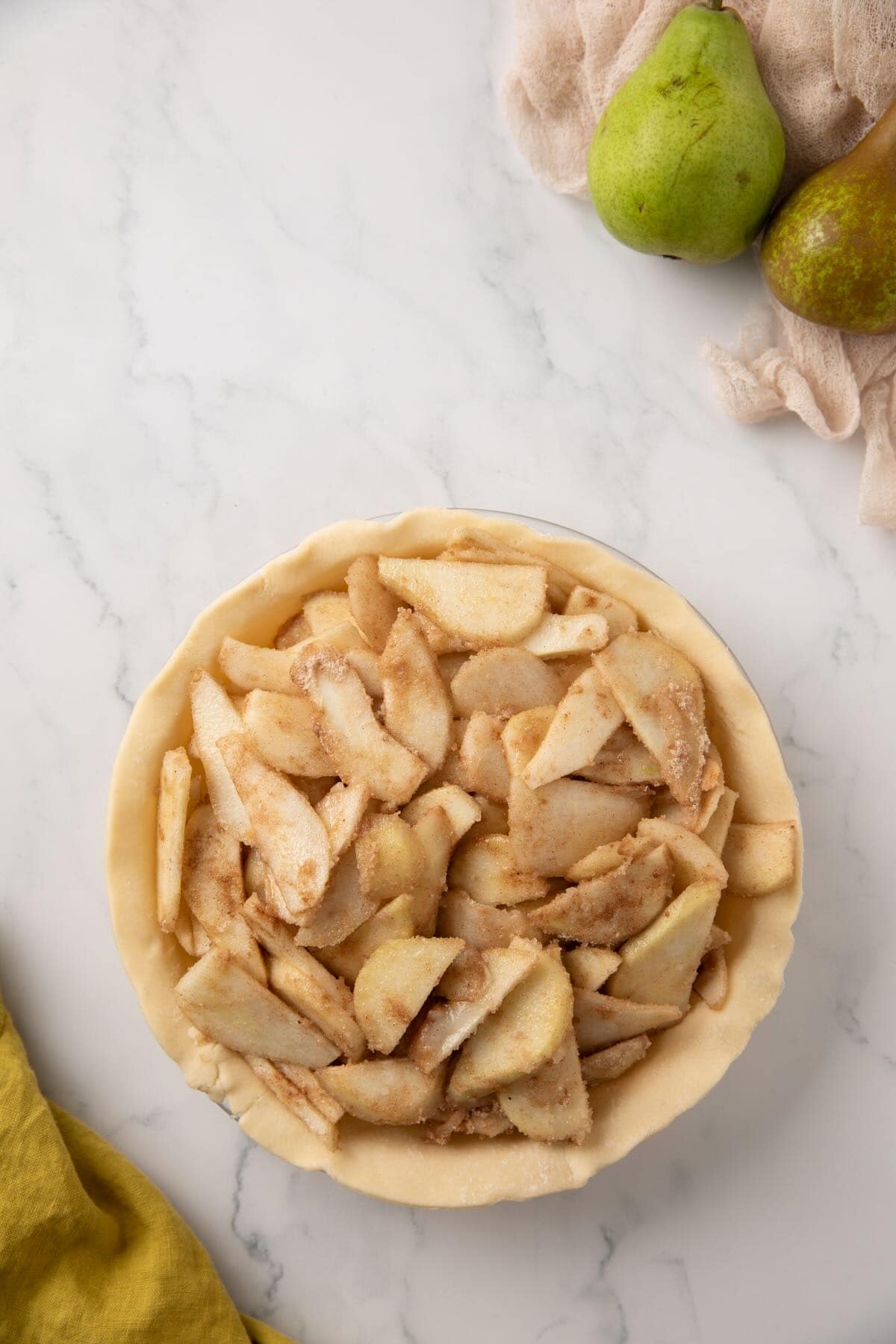 Pear pie filling in a bottom crust in a pie plate. 