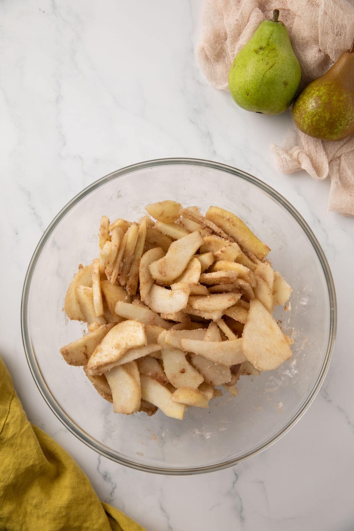 Pear pie filling in a bowl with sliced pears and spices. 