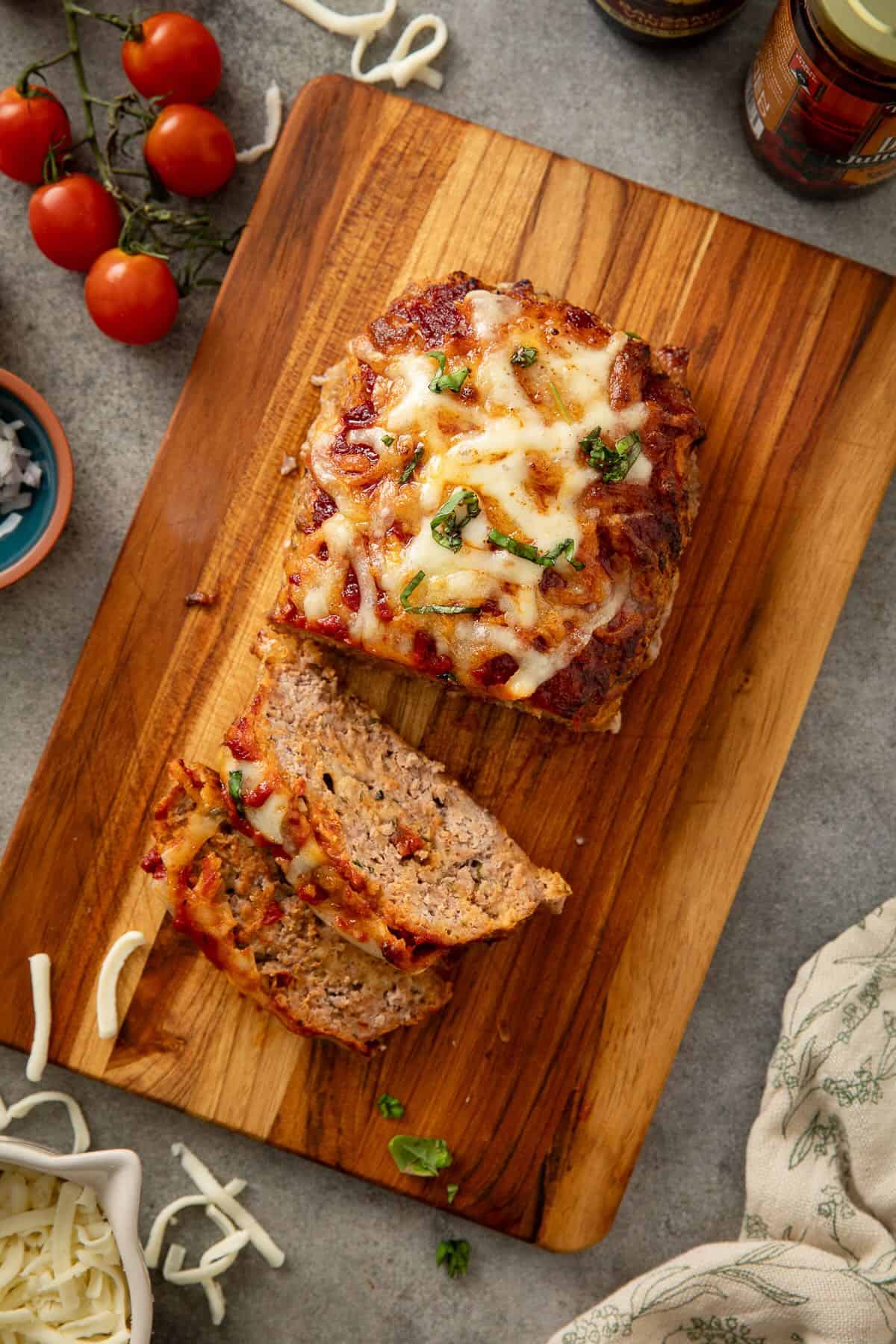A 1-pound meatloaf baked an topped with melted cheese and a tomato based glaze on a cutting board.