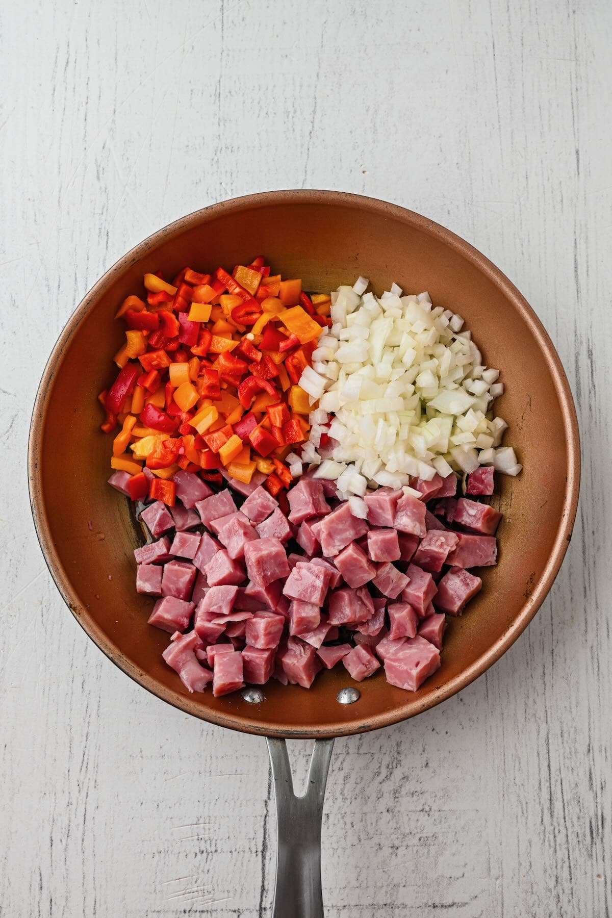 Onions, bell pepper, and ham in a skillet.