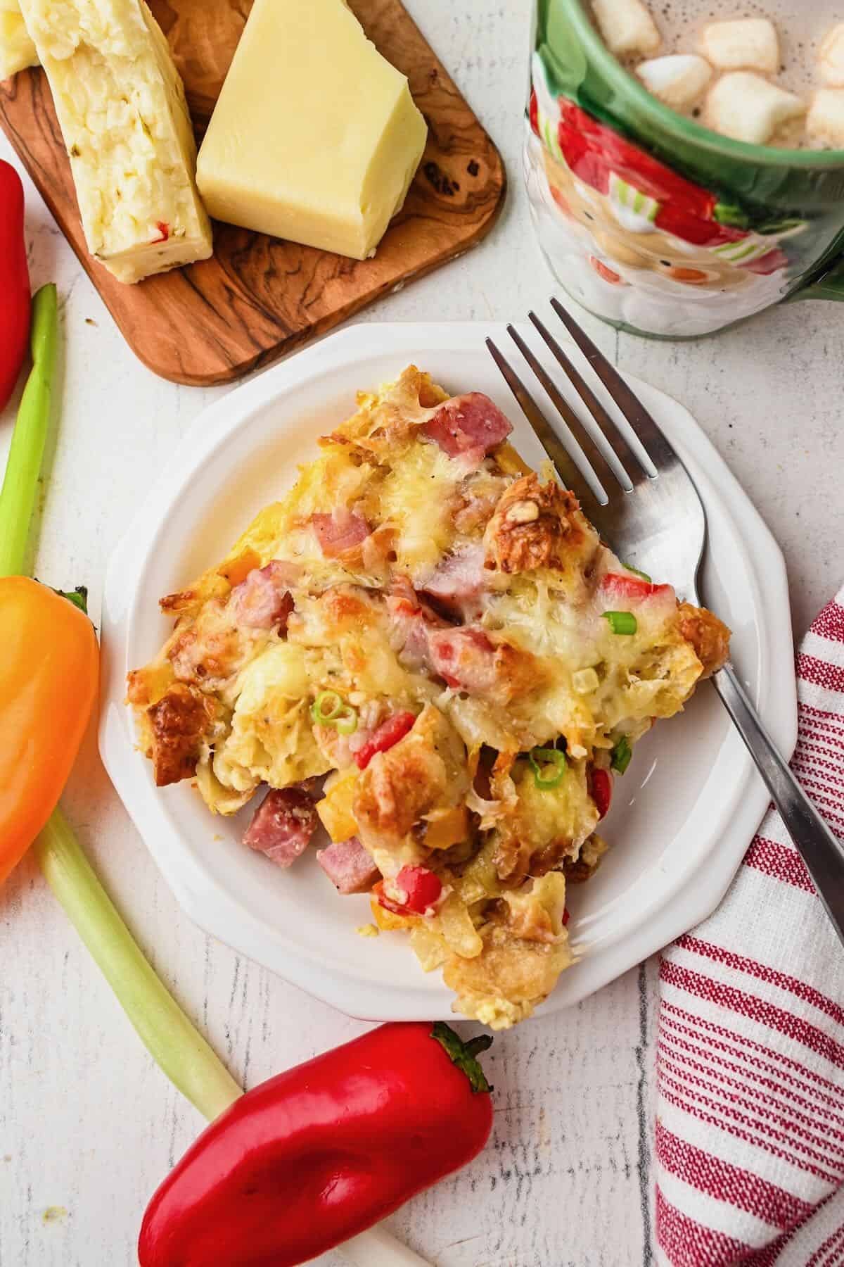 A serving of croissant breakfast casserole on a white plate with forks. 